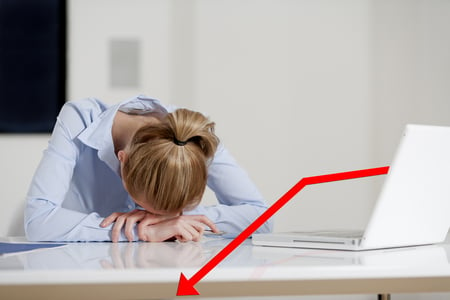 Young woman at her desk displaying a concept of loss and decline